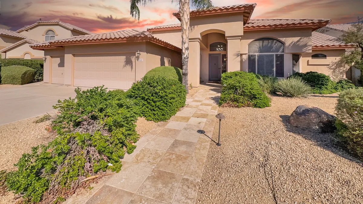 A welcoming view of the home's front entrance, framed by a landscaped pathway and vibrant greenery. The inviting design suggests easy comings and goings, ideal for families eager to explore local attractions or return to comfort after a day out.