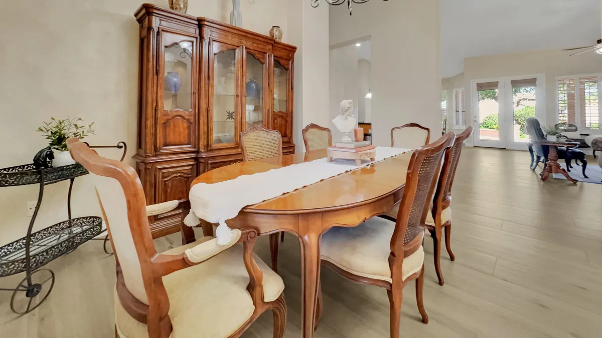 An elegant dining area with a stately table, china cabinet, and artistic accents, set for entertaining and memorable gatherings. The setting is refined yet inviting, ideal for hosting festive meals after enjoying Scottsdale’s seasonal events.