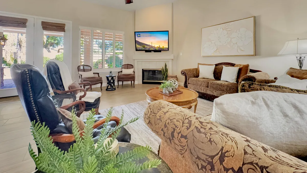 A comfortable seating area featuring a soft sofa, coffee table, fireplace, and television, accented with tasteful Venetian-inspired art. The ambiance is perfect for relaxing, entertaining, or enjoying a quiet movie night.