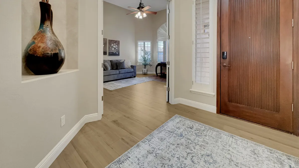 A warmly lit living area with a beautiful decorative vase, a sturdy wooden door, and a cozy seating arrangement. The setting feels welcoming, ideal for intimate family moments or warmly greeting guests.